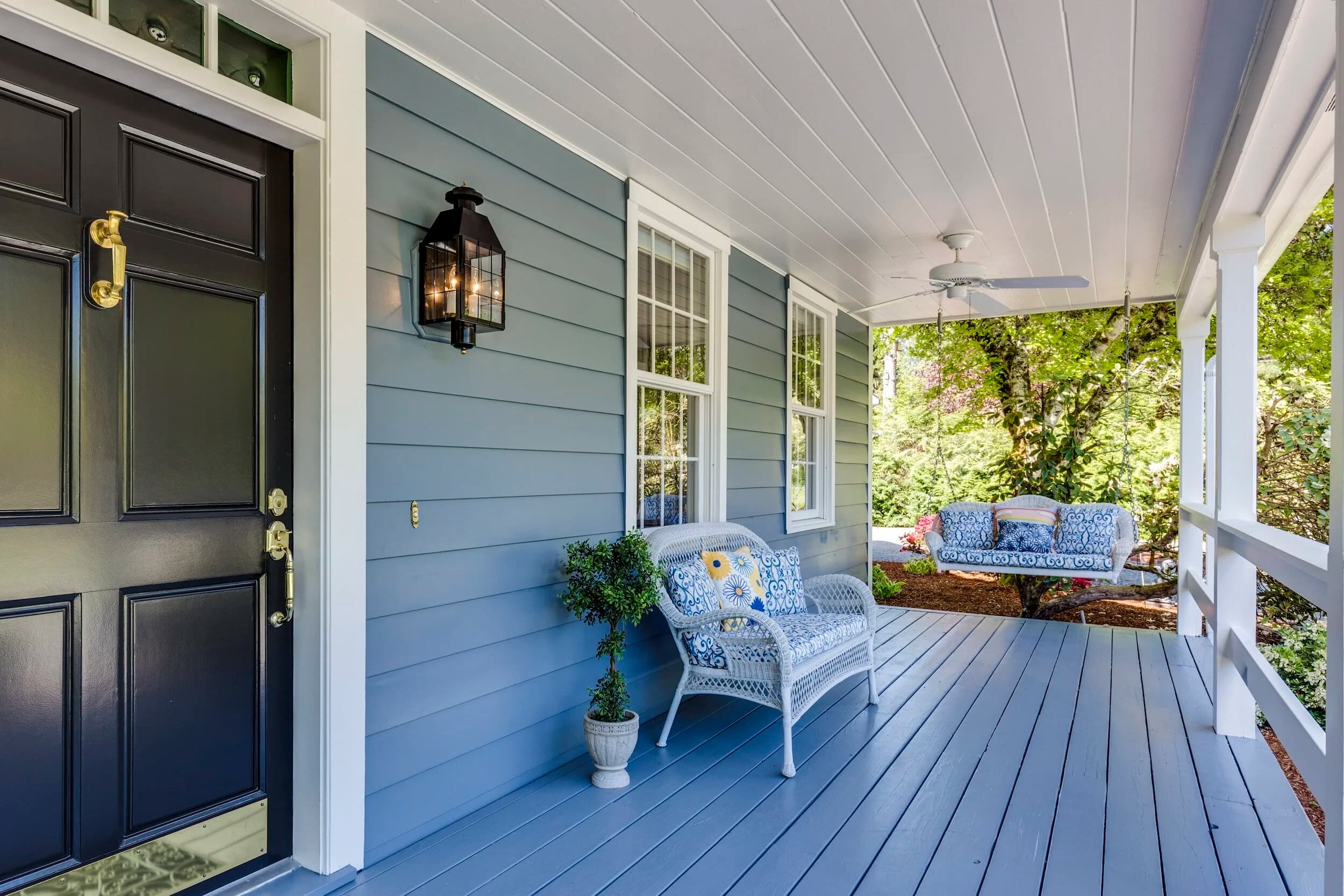 Finished porch remodel with white trim and blue-grey siding